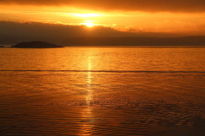 Scenic view of sea against orange sky