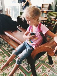 Full length of girl sitting on chair