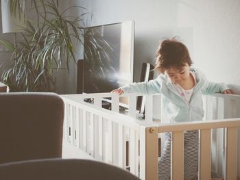 Woman looking at camera while sitting on chair at home