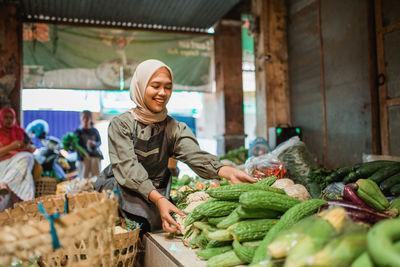 Portrait of smiling young woman standing in market