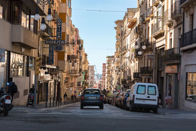 Cars on street amidst buildings in city