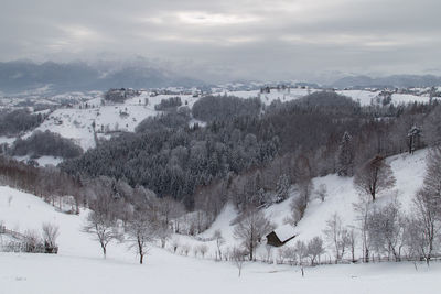 Panoramic view of snow covered field against sky