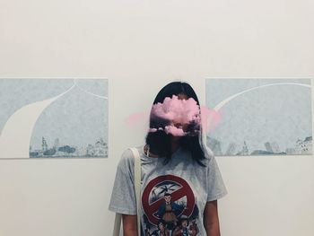 Portrait of woman standing against wall