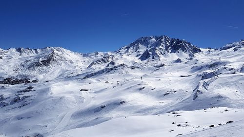 Scenic view of snowcapped mountains against clear blue sky