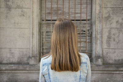 Rear view of woman in front of building