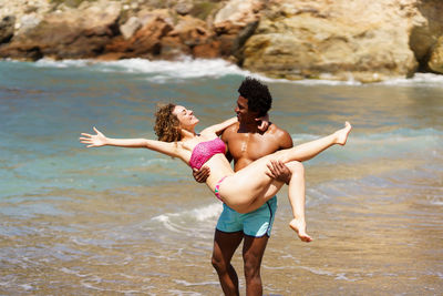 Full length of young woman jumping in lake