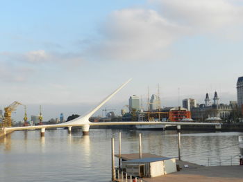 Bridge over river in city against sky