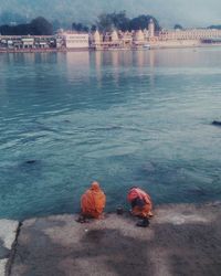 High angle view of men on retaining wall in front of ganges river