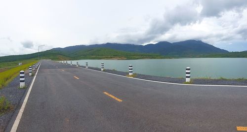 Road by mountains against sky