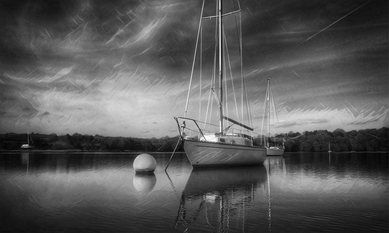 SAILBOAT SAILING IN RIVER AGAINST SKY