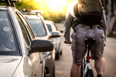 Rear view of man cycling on street in city