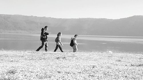 People on shore against sky