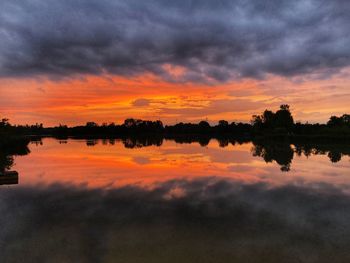 Scenic view of lake against orange sky