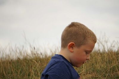 Portrait of boy looking away on field