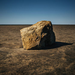 Rock formations on shore against clear sky