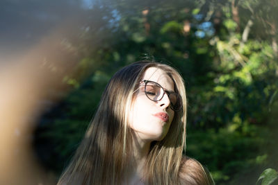 Beautiful woman standing by plants outdoors