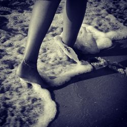 Low section of woman standing on beach