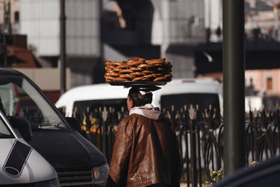 Rear view of woman standing by car