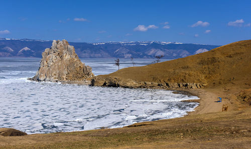 Scenic view of sea and snowcapped mountains against sky