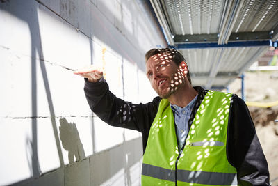 Architect gesturing while analyzing at construction site