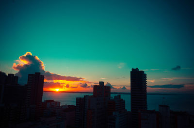 Buildings in city against sky during sunset