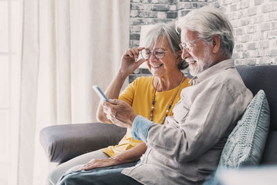 Side view of senior couple sitting on sofa at home