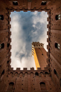 Directly below shot of torre del mangia against sky