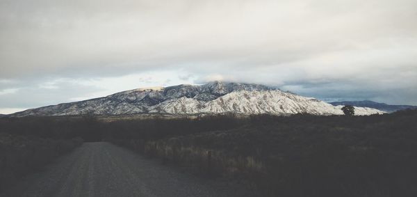 Scenic view of mountains against cloudy sky