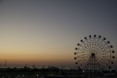 Silhouette ferris wheel against sky at sunset