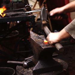 Cropped hands of man working on metal in workshop