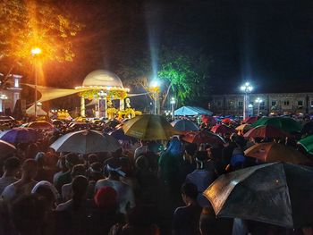 Crowd at illuminated city during night