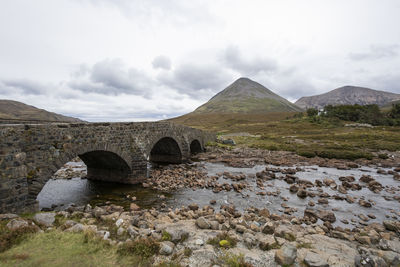 Arch bridge over water against sky