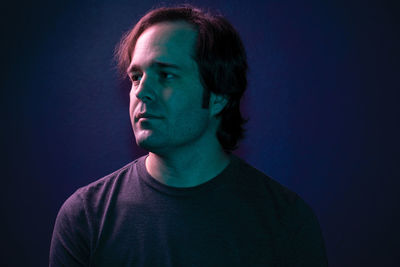 Portrait of young man against blue background