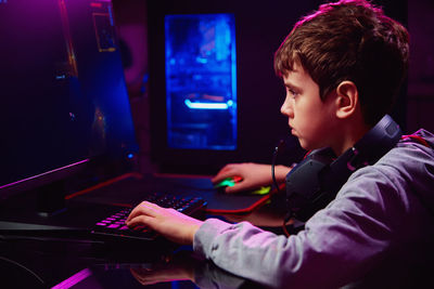 Boy plays computer game at home, gaming addiction