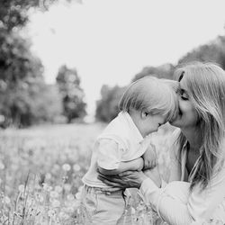 Mother and daughter on field against sky