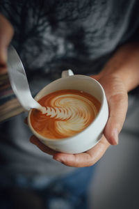 Cropped hand making coffee at cafe