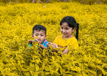 High angle view of children on yellow flowering plants