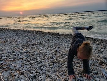 Full length of girl on beach against sky during sunset