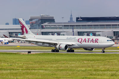 Airplane on airport runway against sky