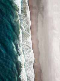 Aerial view of sea waves rushing at beach