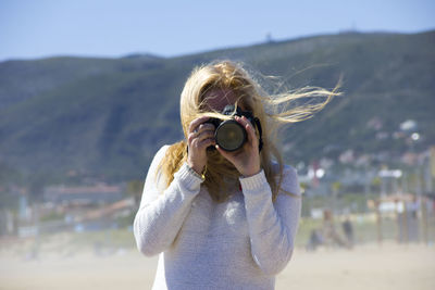 Woman photographing on sunny day