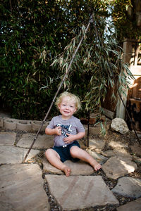 Portrait of smiling boy sitting outdoors