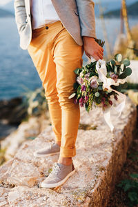 Low section of man standing on rock