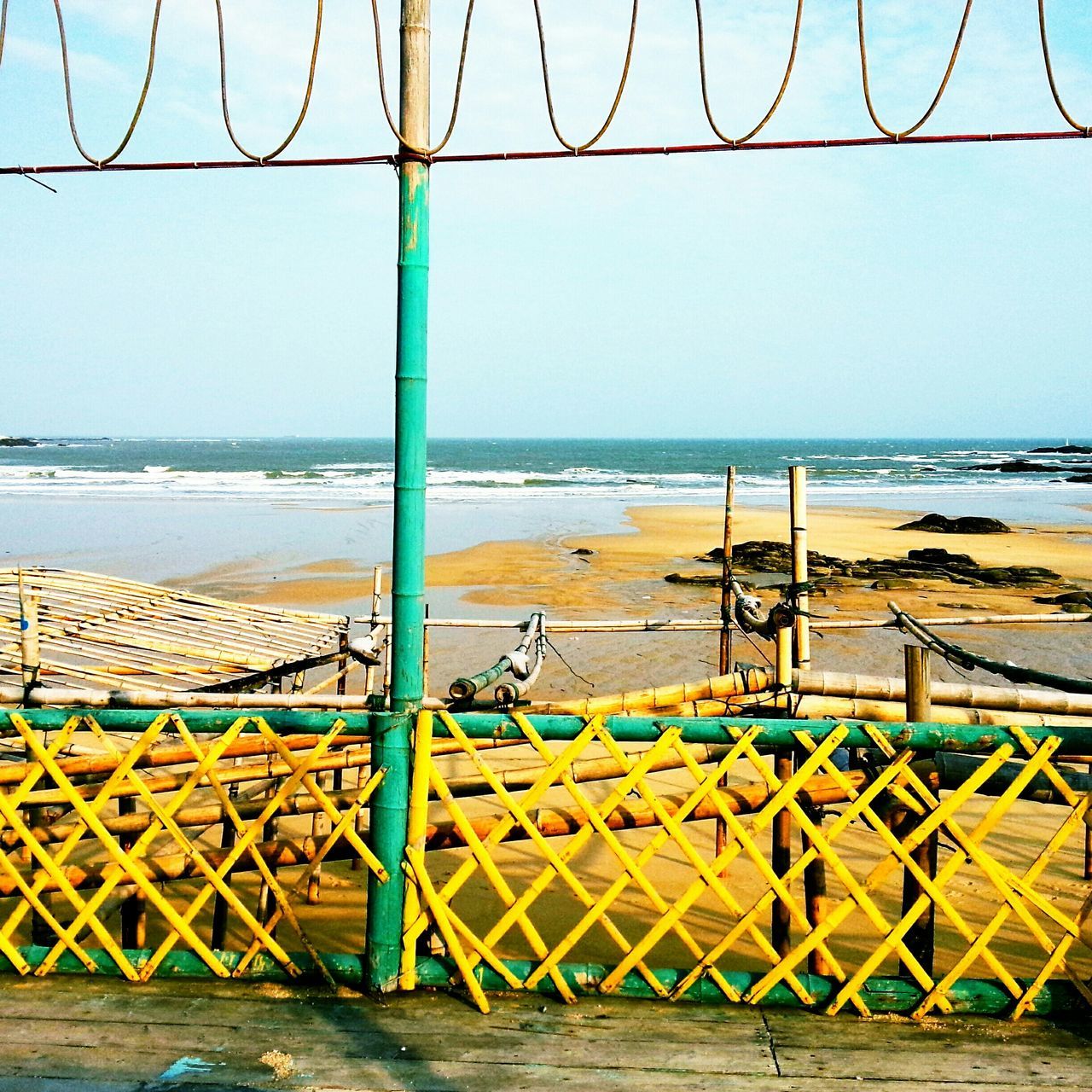 sea, horizon over water, beach, water, blue, shore, clear sky, sand, railing, protection, fence, sky, tranquility, built structure, day, tranquil scene, nature, scenics, sunlight, safety