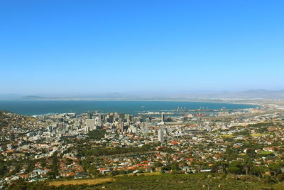 High angle view of townscape by sea against clear sky