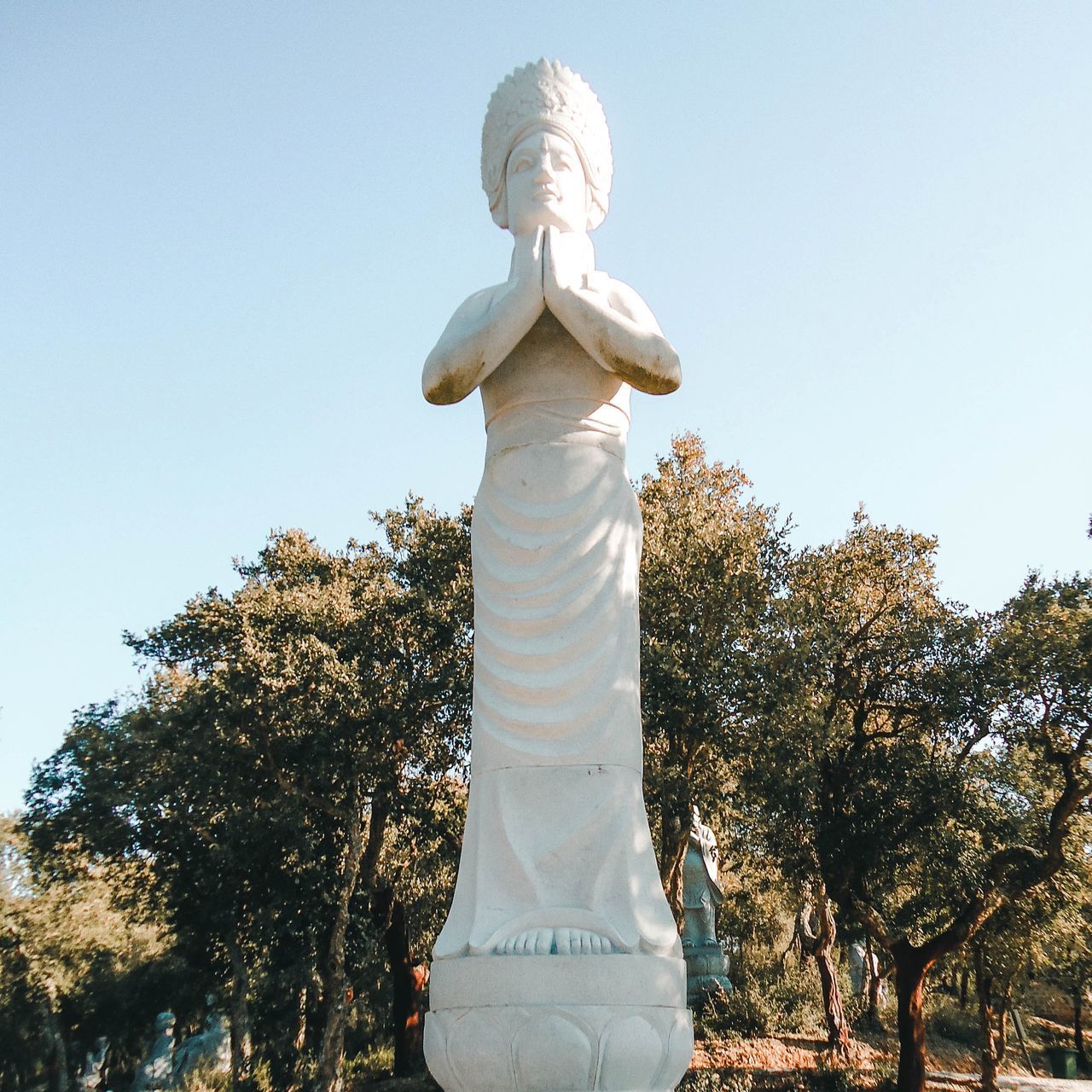 LOW ANGLE VIEW OF STATUE AGAINST TREES