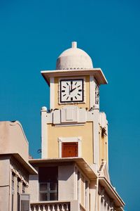 Low angle view of clock tower against blue sky