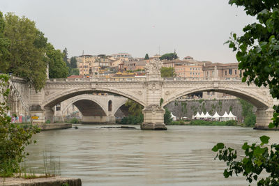 Arch bridge over river against clear sky