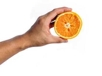 Close-up of hand holding apple against white background