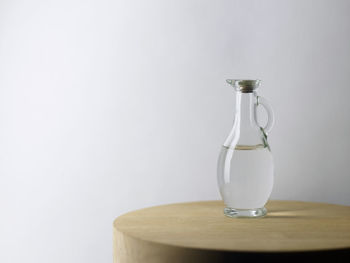 Water in jug on table against white background